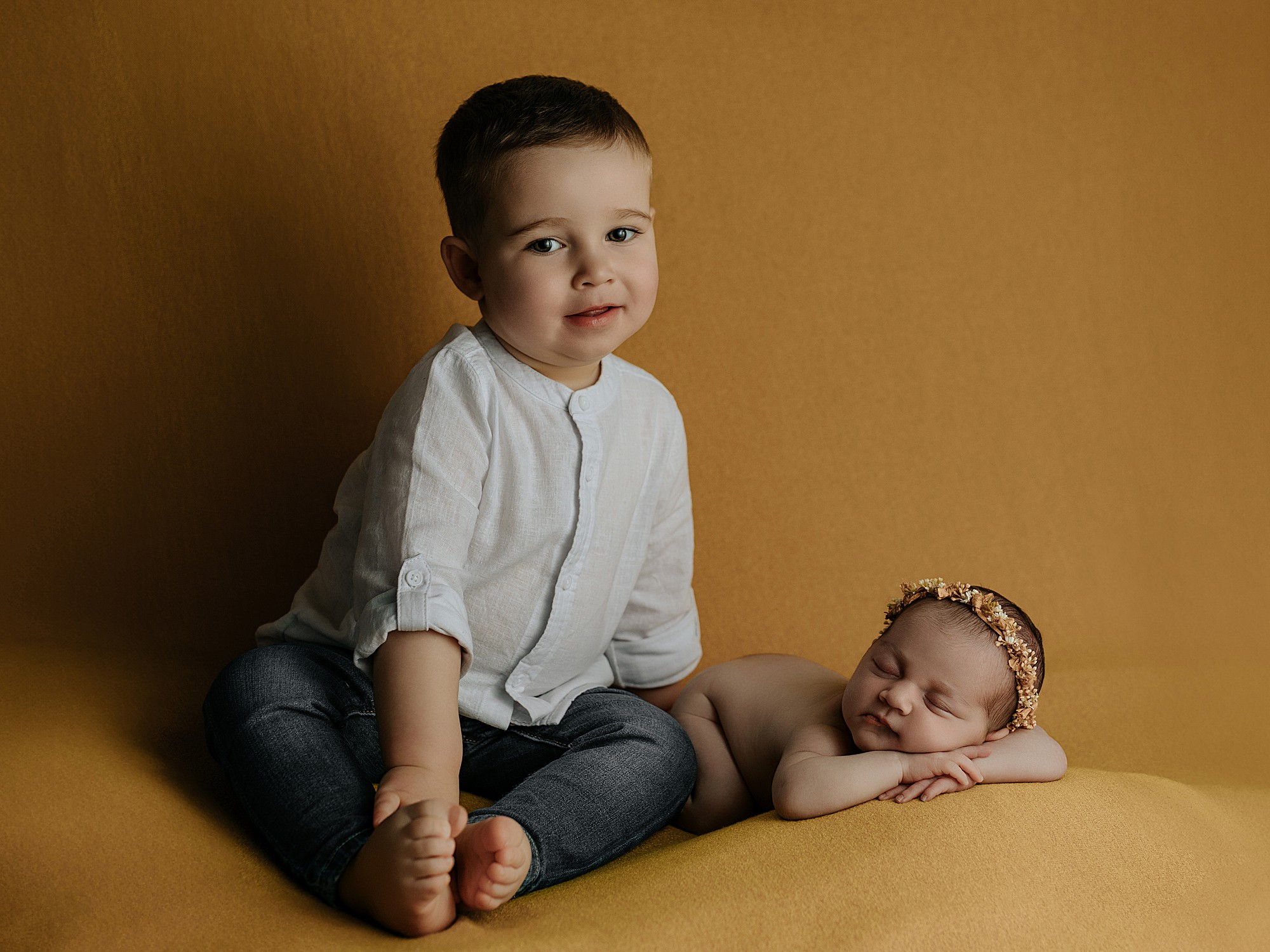 Lara recién nacida con su hermano Mateo durante una sesión newborn en Santiago de Compostela