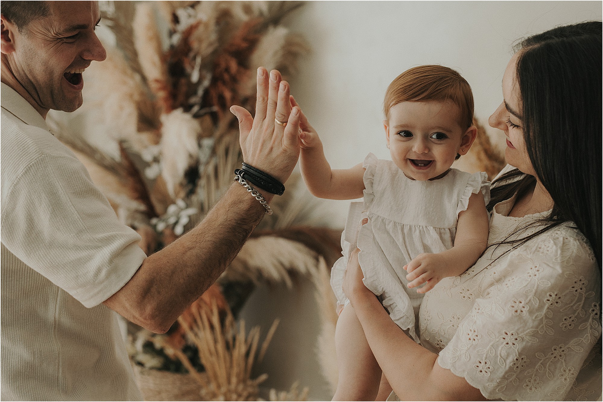 Bebé de un año jugando con sus padres durante una sesión familiar
