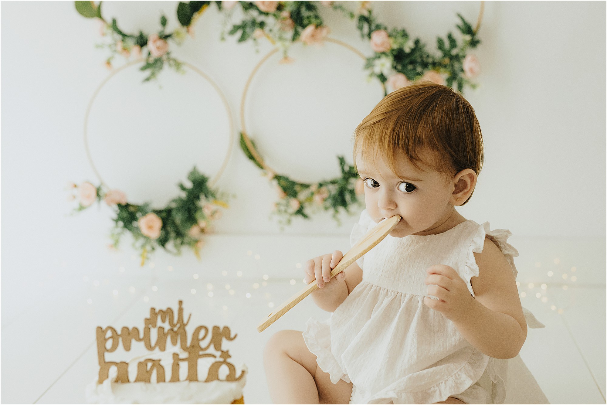 Bebé de un año en un decorado floral de primer cumpleaños