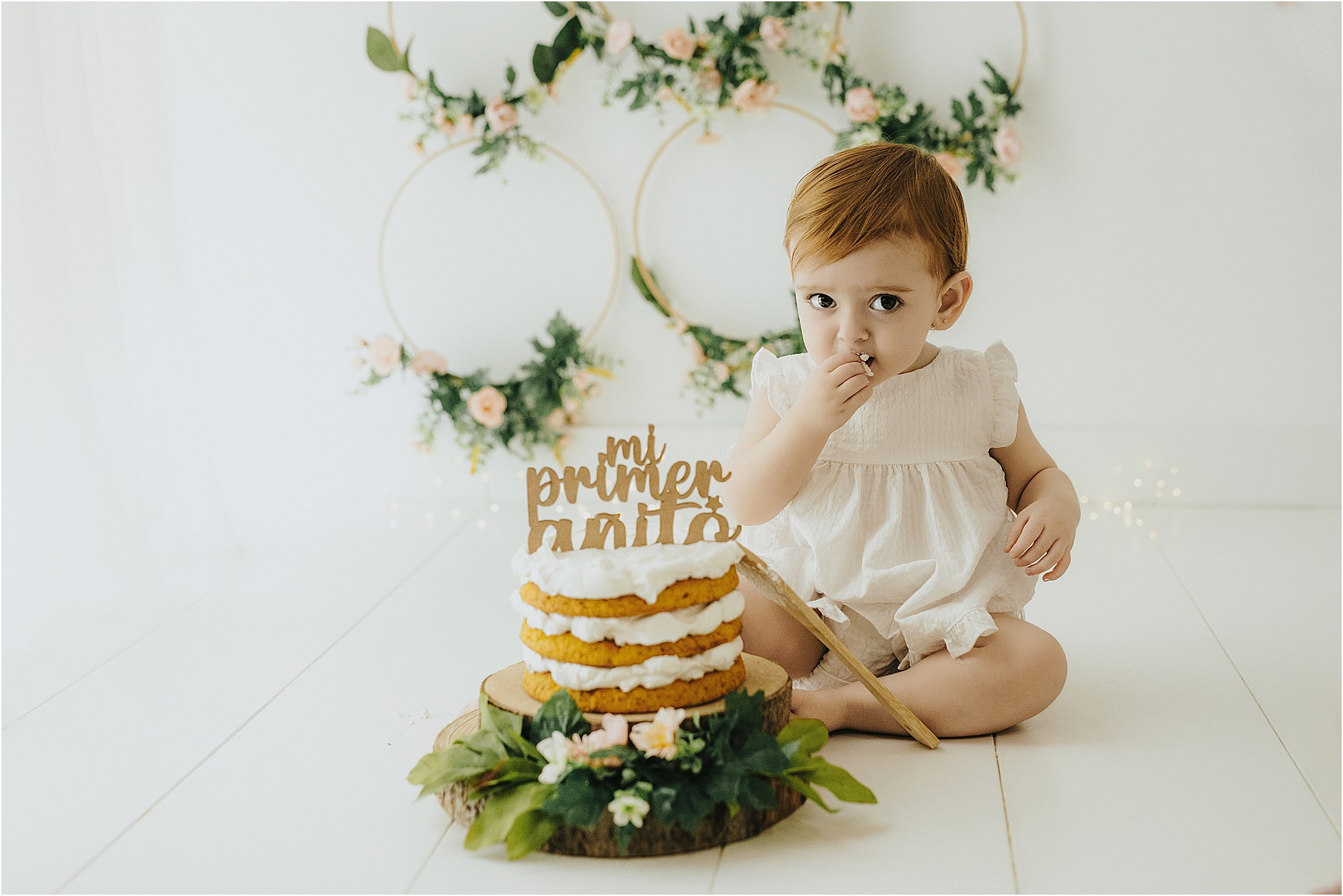 Bebé junto a su tarta de primer cumpleaños en el estudio