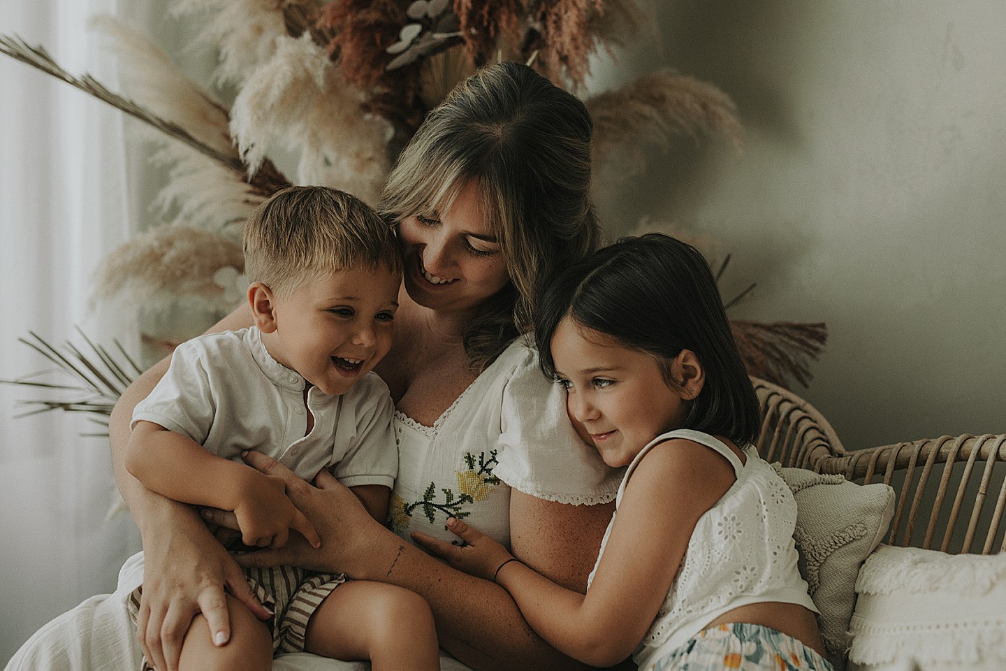 Madre abrazando a sus hijos en una sesión de fotografía familiar