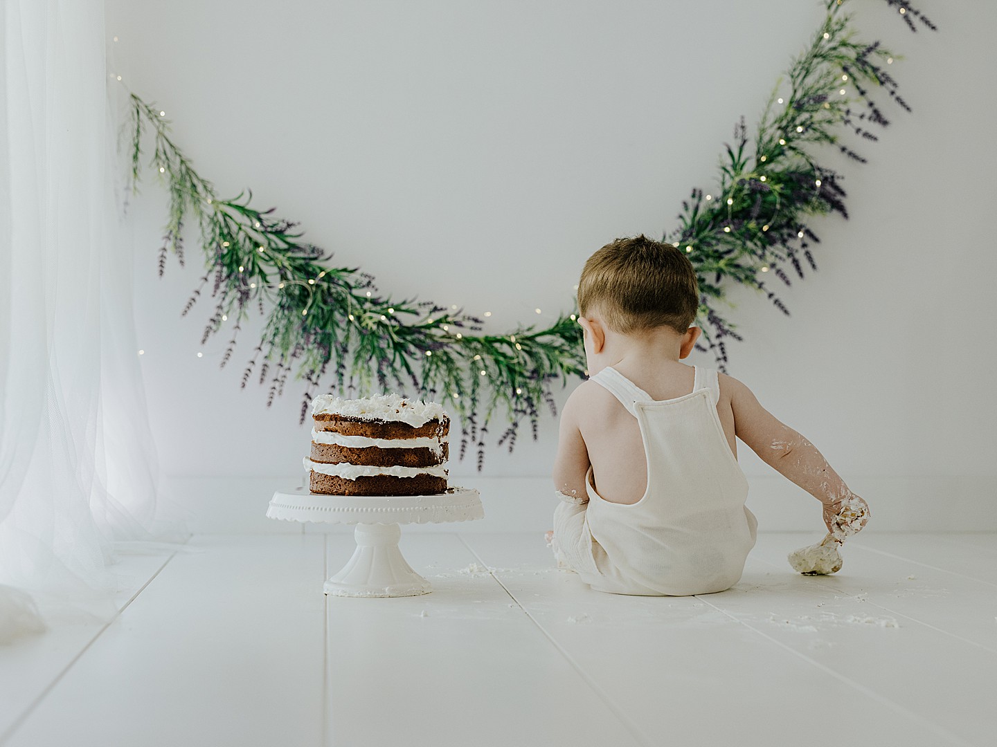 Retrato de bebé junto a su tarta de cumpleaños