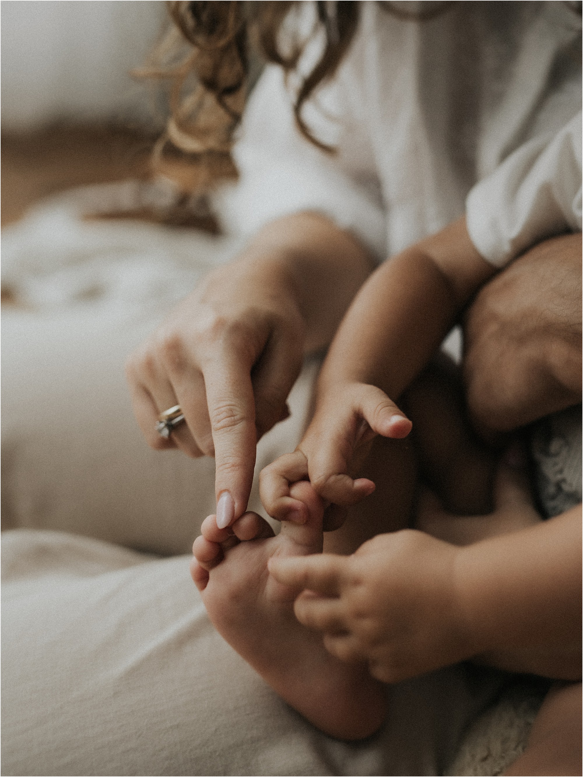 Detalle de las manos de los padres y los pies de su hija