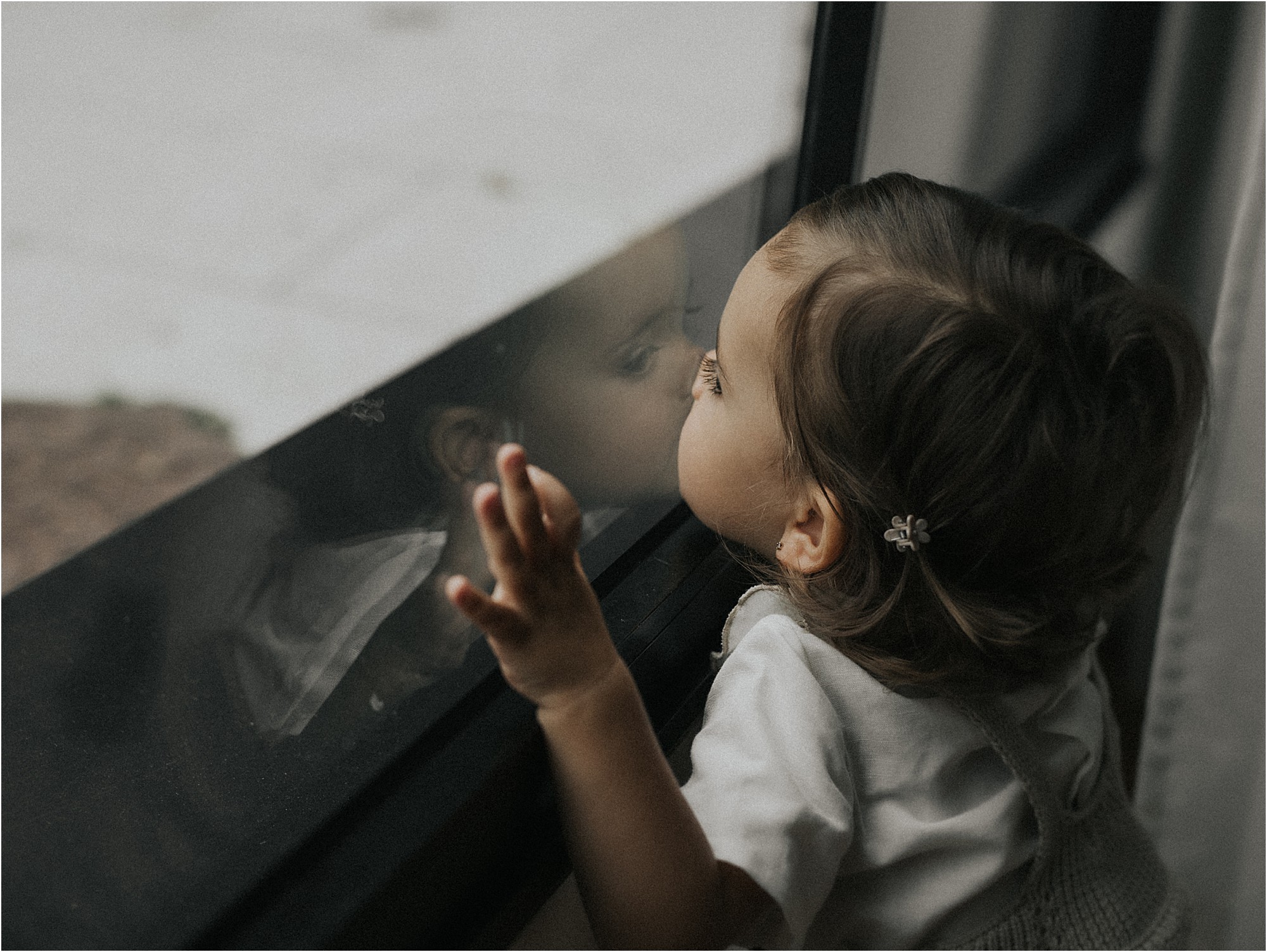 Niña curiosa mirando por la ventana del estudio