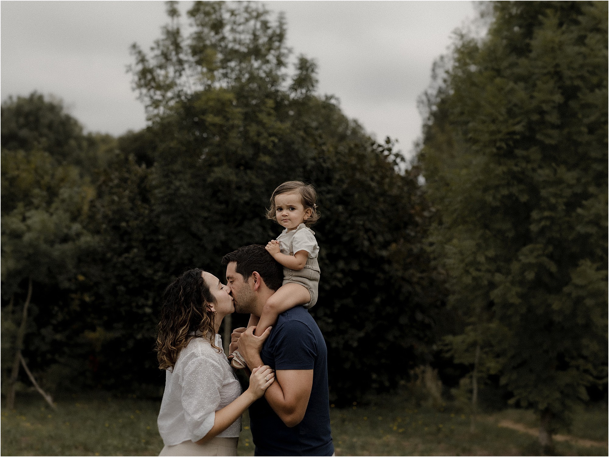 Familia abrazada en un jardín durante una sesión de fotos